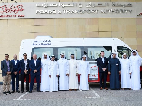 an image of RTA team standing in front of Bus on demand vehicle