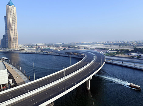 an image of A bridge of three lanes in each direction crossing over Dubai Water Canal