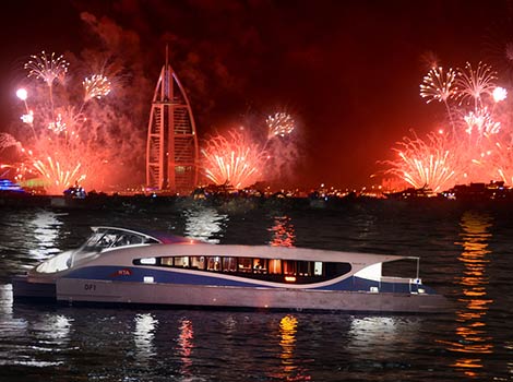 an image of Dubai ferry in front of new year eve fireworks 